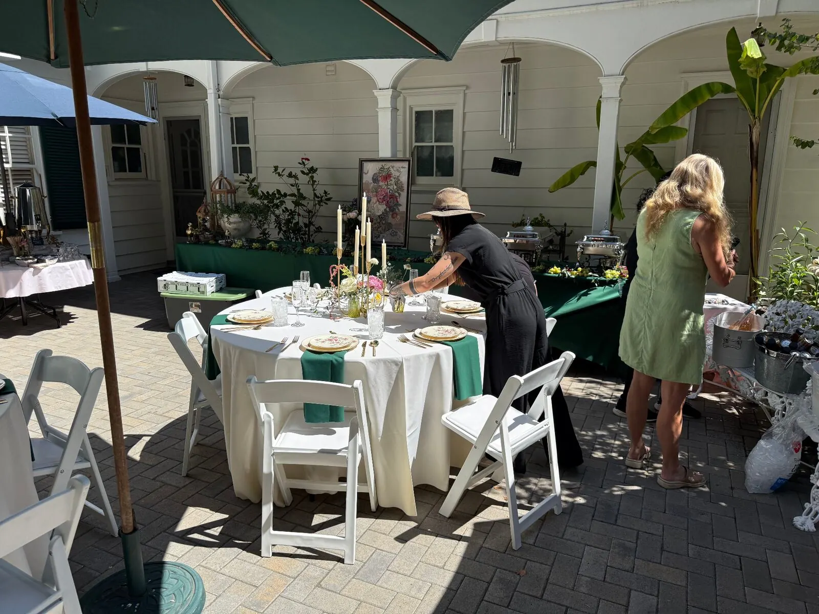 Outdoor courtyard table setup with emerald linens by Tracy Catering Company