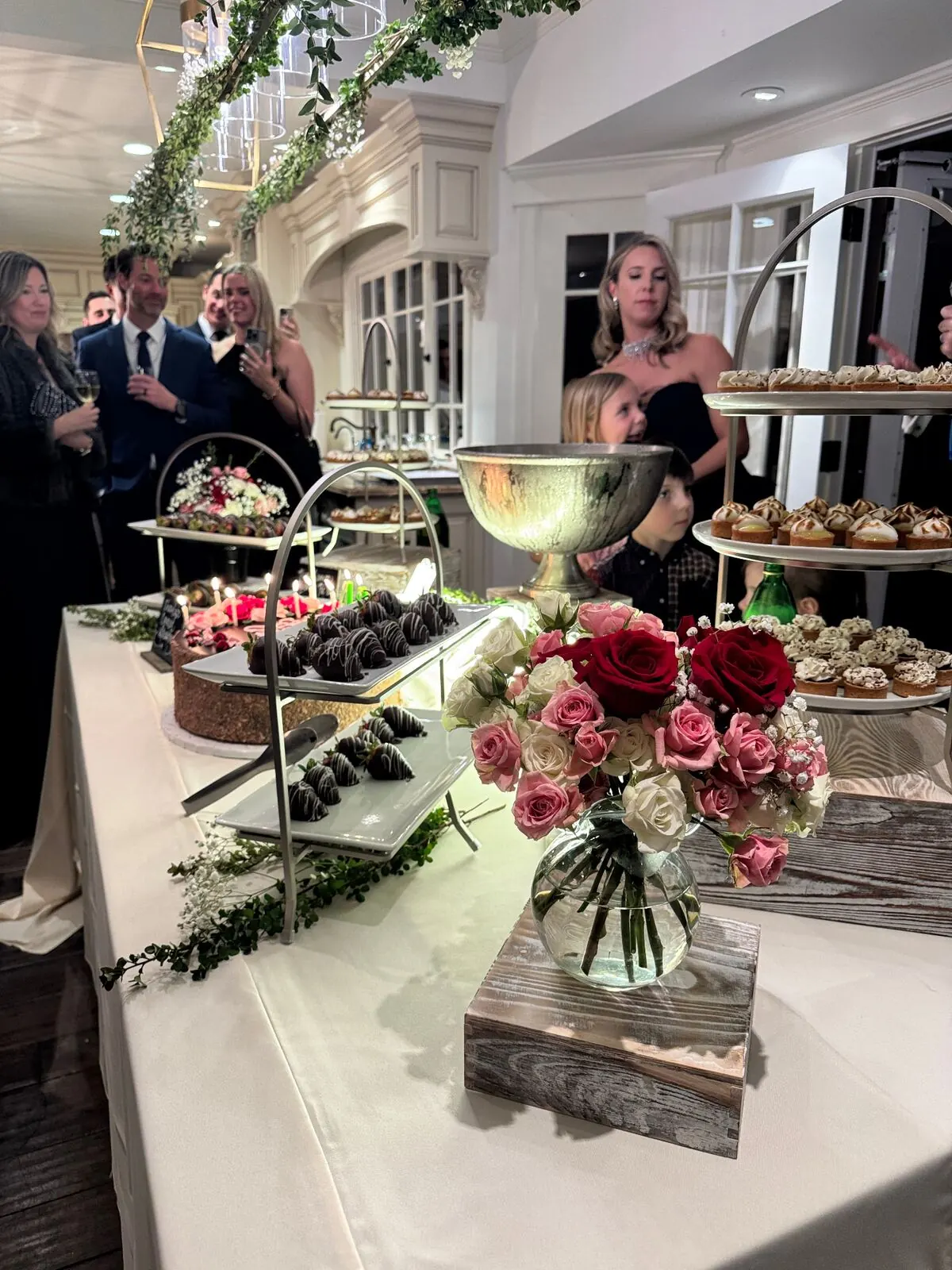 Wedding dessert table with chocolate-covered strawberries and garden roses worked into the display — floral dessert styling for Tracy catering weddings